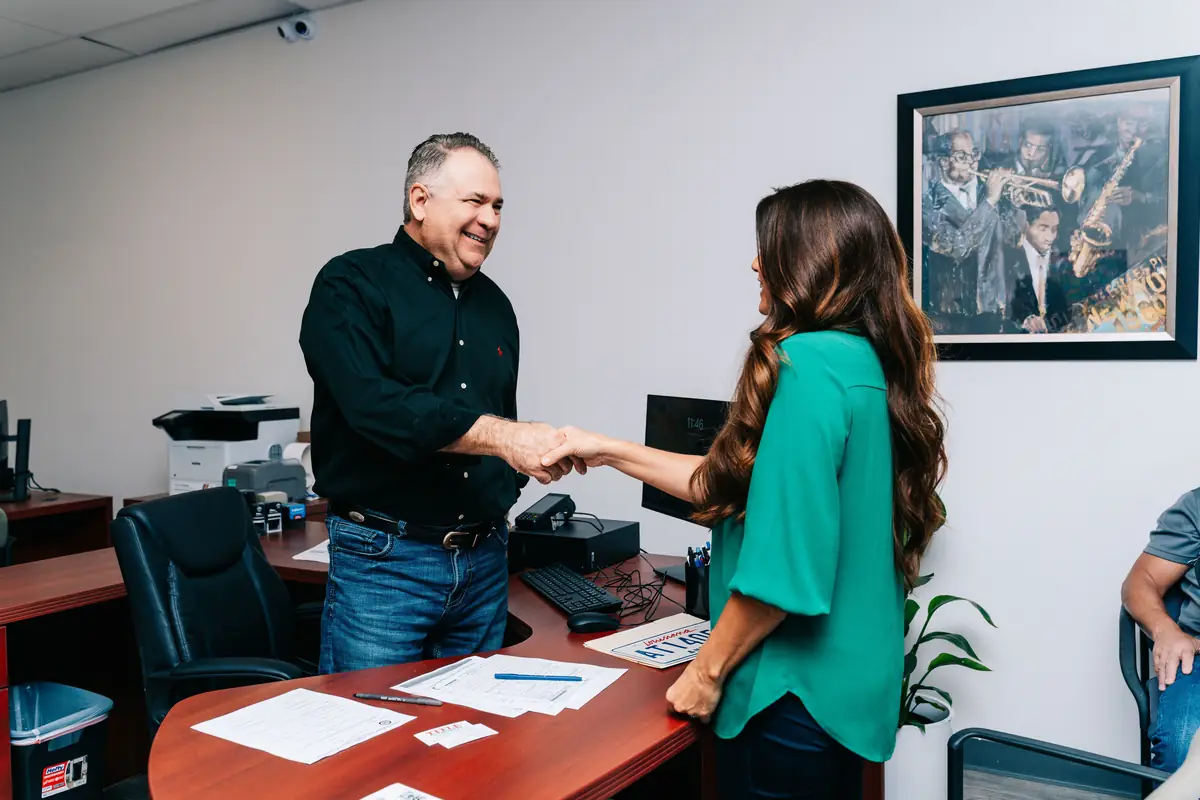 Louis Dutel shaking hands with a customer at Title Authority in Covington