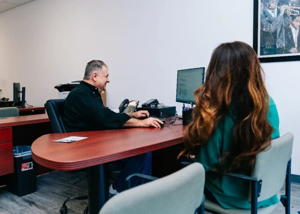 Louis Dutel going over paperwork with a customer at the Title Authority office in Covington